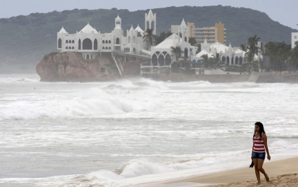 A woman walks on the shore of the beach in Mazatlan on the Mexican mainland and on the Pacific coast near Baja California